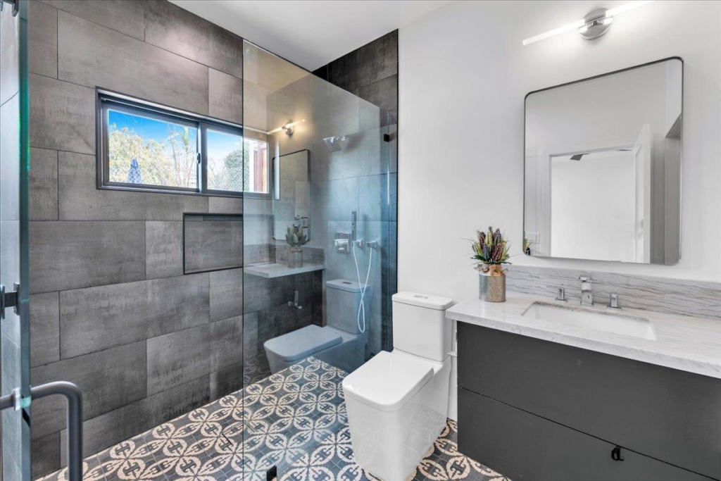Modern bathroom interior design with patterned tile and glass shower in San Diego, CA